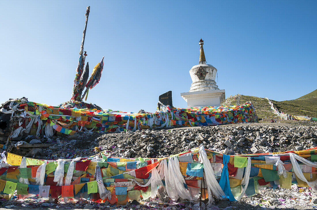 Buddhistische Stupa und tibetische Flaggen an der Straße in der Nähe des Dorfes Litang, der ersten tibetischen Stadt von Chengdu; Litang, Sichuan, China