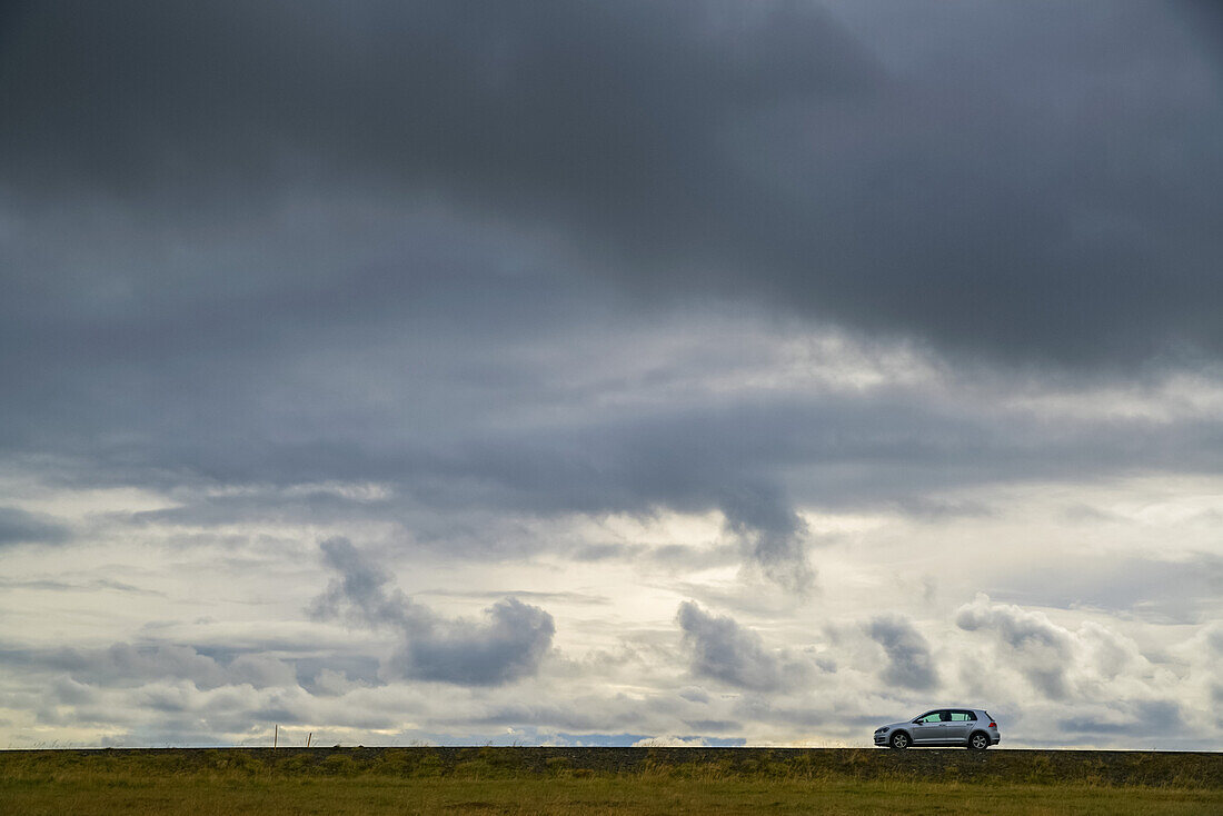 Ein einsames Auto fährt auf dem Highway auf der Snaefellsness Halbinsel; Island