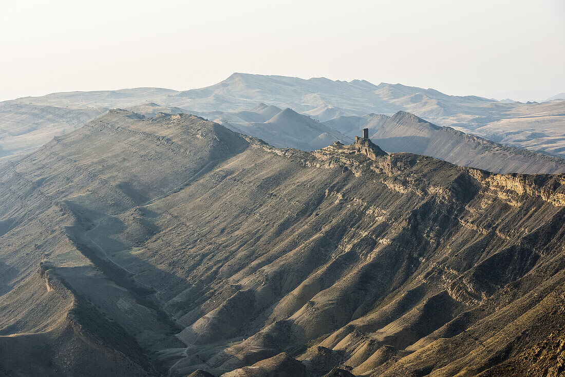 Ein Bergrücken in der Nähe des David-Gareja-Klosterkomplexes an der umstrittenen Grenze zwischen Georgien und Aserbaidschan mit deutlich sichtbaren Überresten eines alten Klosterturms; Kachetien, Georgien.