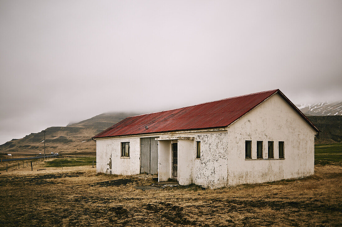 Verwittertes Gebäude unter Wolken auf der Halbinsel Snaefellsnes; Island