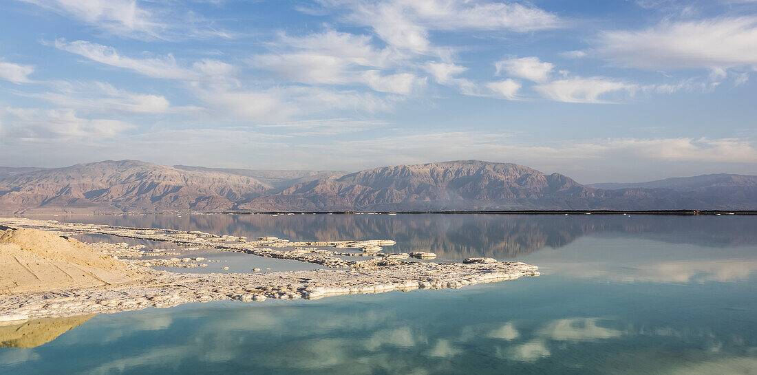 Der Himmel und die Berge der judäischen Wüste spiegeln sich im ruhigen Wasser des Toten Meeres; Süddistrikt, Israel