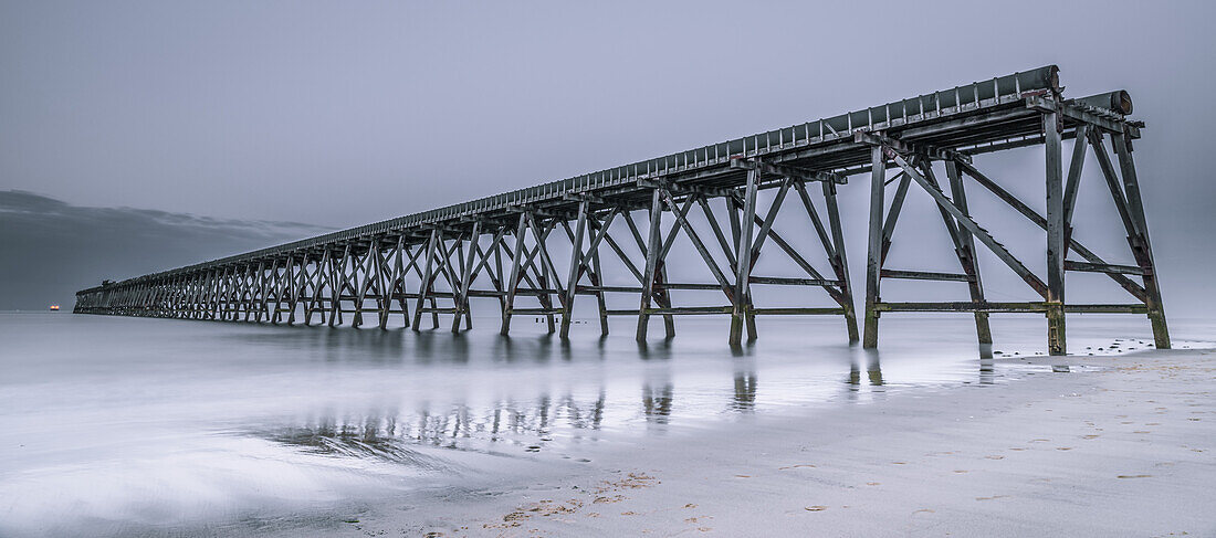 The disused Steetley Pier in the 'blue hour' built to serve the former Hartlepool Magnesia Works which has now been demolished; Hartlepool, County Durham, England