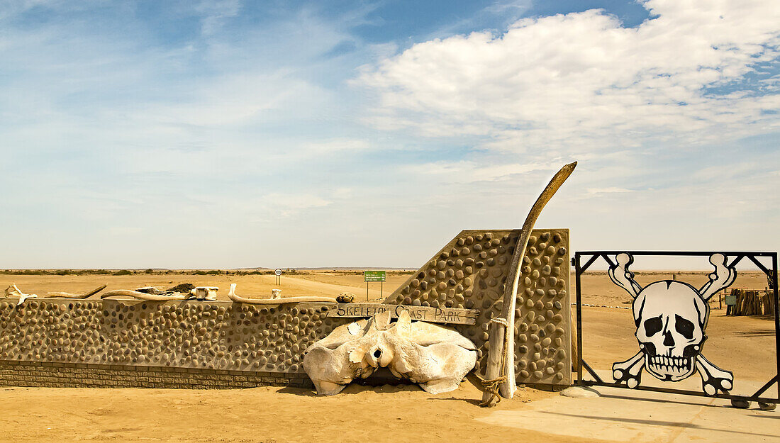 A closed gate with skull and crossbones in the Namib desert, Skeleton Coast; Sossusvlei, Hardap Region, Namibia