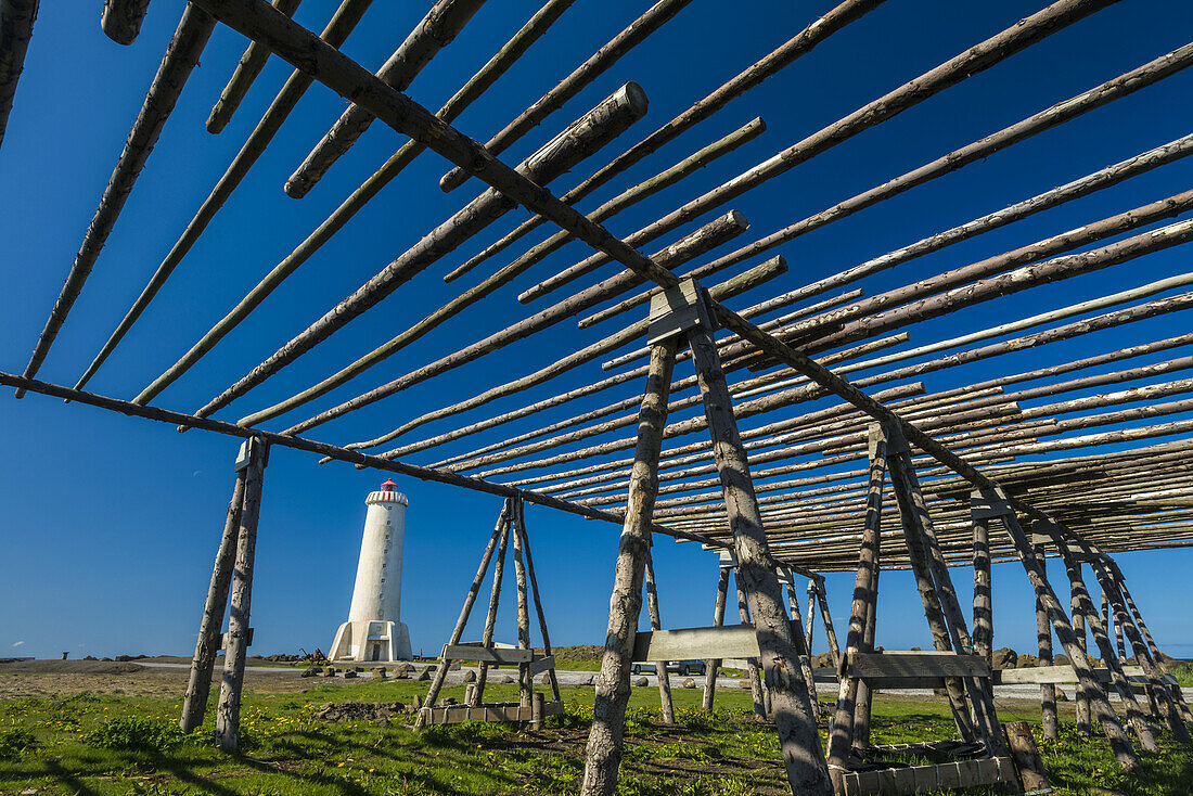 Old fish drying racks next to a lighthouse; Akranes, Iceland