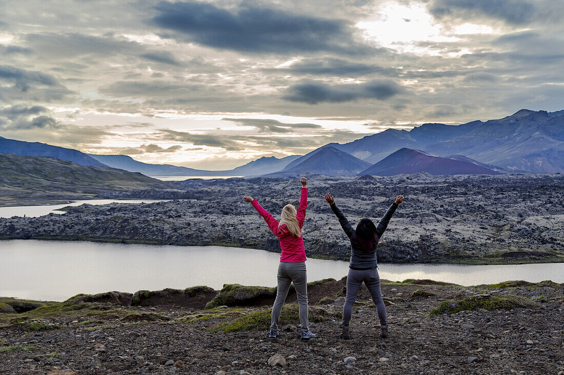 Zwei weibliche Reisende feiern ihre Wanderung und genießen die Aufregung an diesem wunderschönen Aussichtspunkt im Westen Islands; Island
