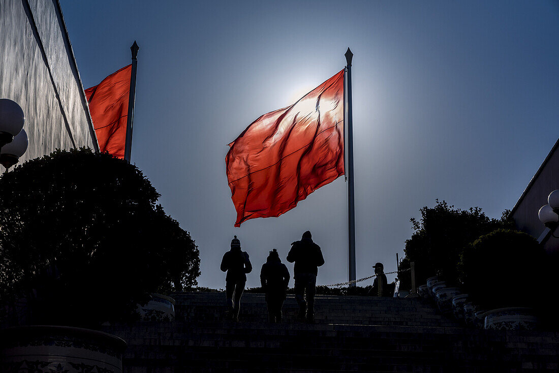 Silhouettes of people and flag in Tiananmen Square; Beijing, China