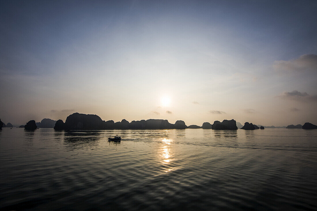 Kalksteinkarst und Inseln der Ha Long Bucht bei Sonnenuntergang; Quang Ninh, Vietnam.