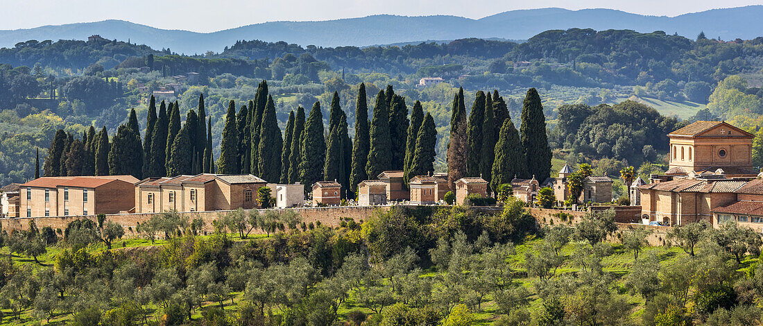 Steingebäude, Kirche und Friedhof in einer baumbestandenen Hügellandschaft; Siena, Toskana, Italienq