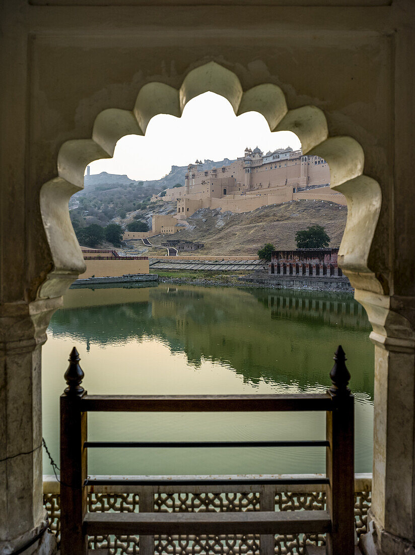 Maota-See vor dem Amer Fort mit Blick durch einen gezackten Torbogen; Jaipur, Rajasthan, Indien.