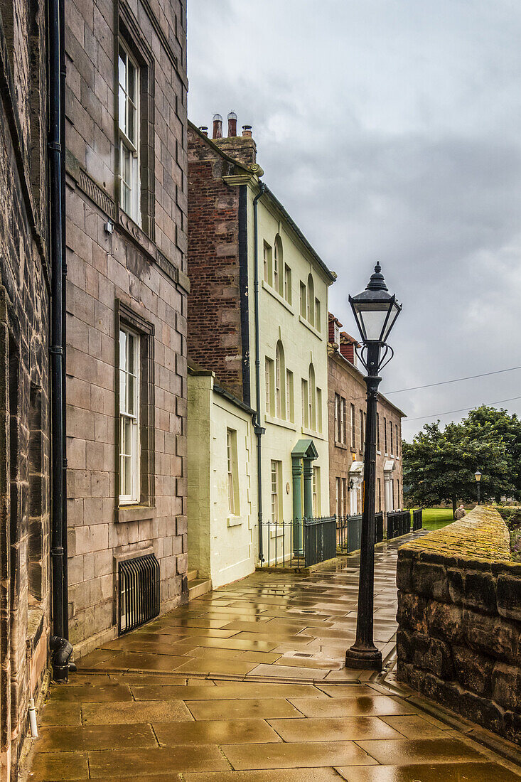 Straße mit georgianischen Häusern und Laternenpfahl mit regennasser Pflasterung; Berwick Upon Tweed, England