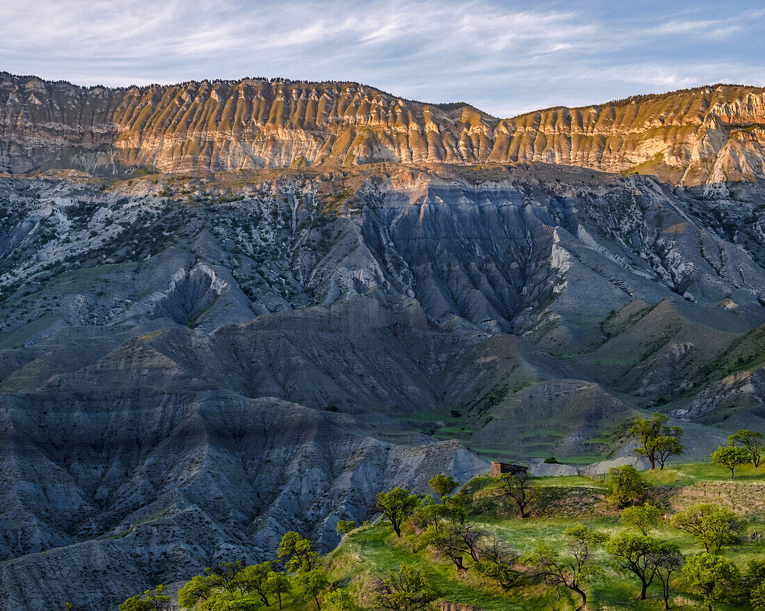 Blick auf ein kleines Haus auf einem Bergrücken und die zerklüftete Landschaft in der Nähe des Dorfes Salta; Republik Dagestan, Russland.