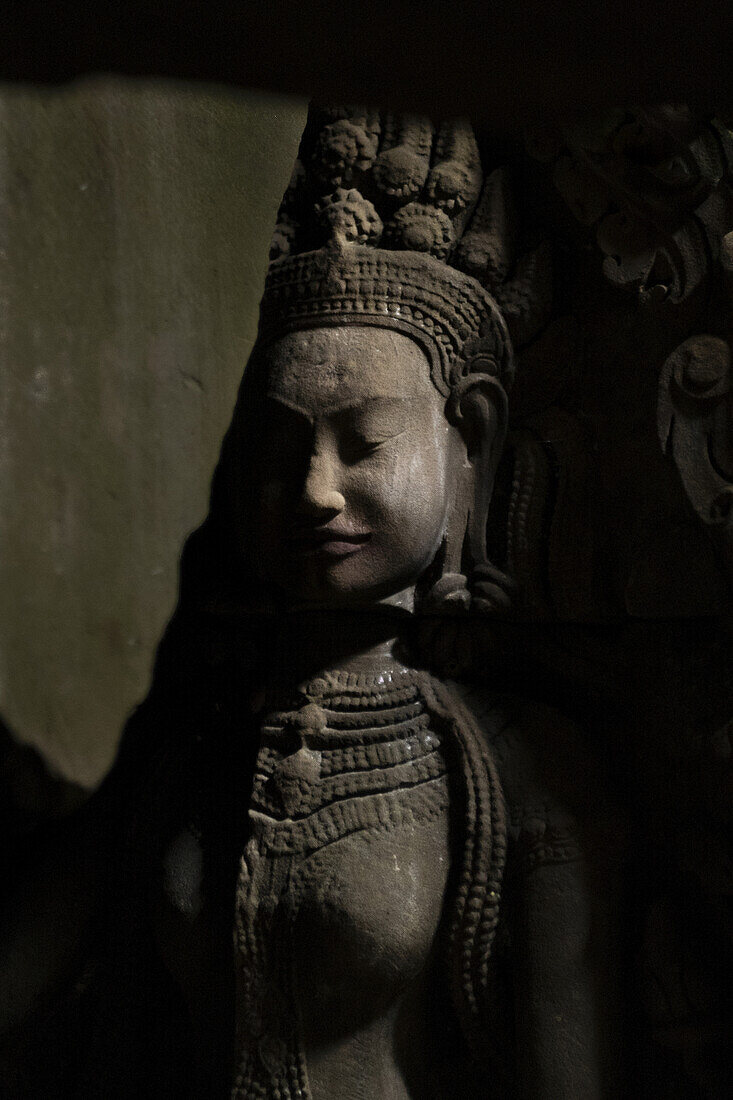 Close-up of a statue of a goddess in a shaft of sunlight, Angkor Wat; Siem Reap, Siem Reap Province, Cambodia
