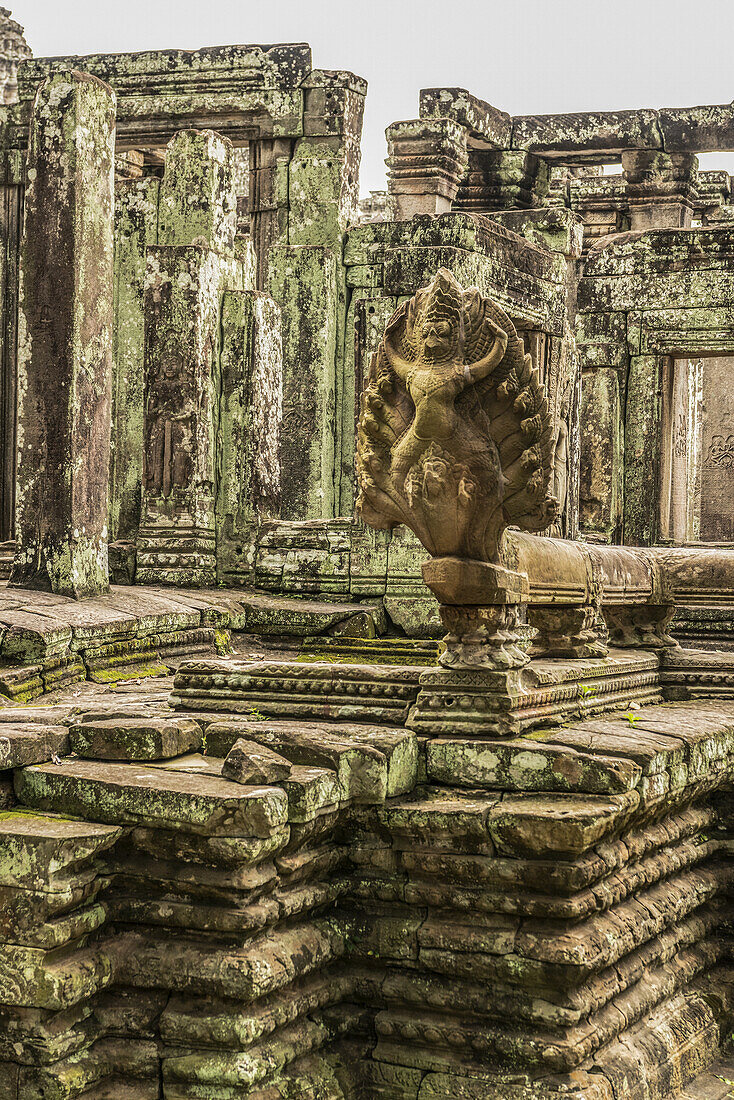 Statue in foreground of ruined Bayon temple, Angkor Wat; Siem Reap, Siem Reap Province, Cambodia