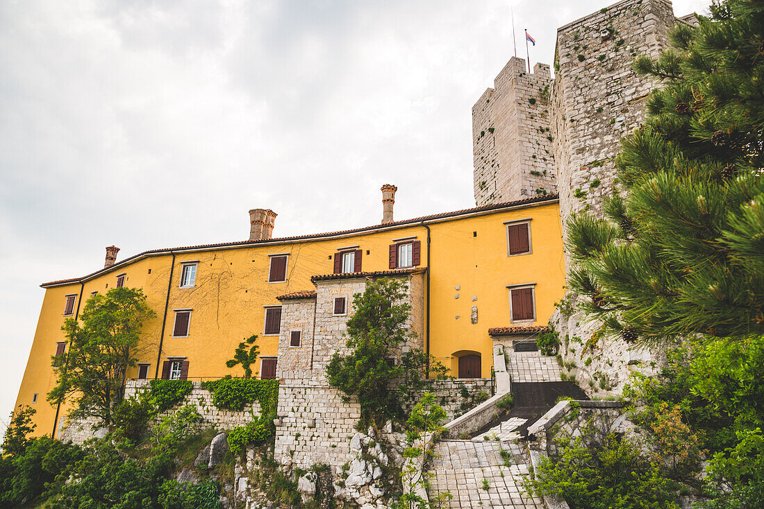 Yellow and stone walls of Duino Castle; Italy