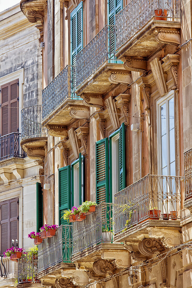 Fassade eines Wohnhauses mit Fensterläden und Balkonen; Syrakus, Sizilien, Ortigia, Italien