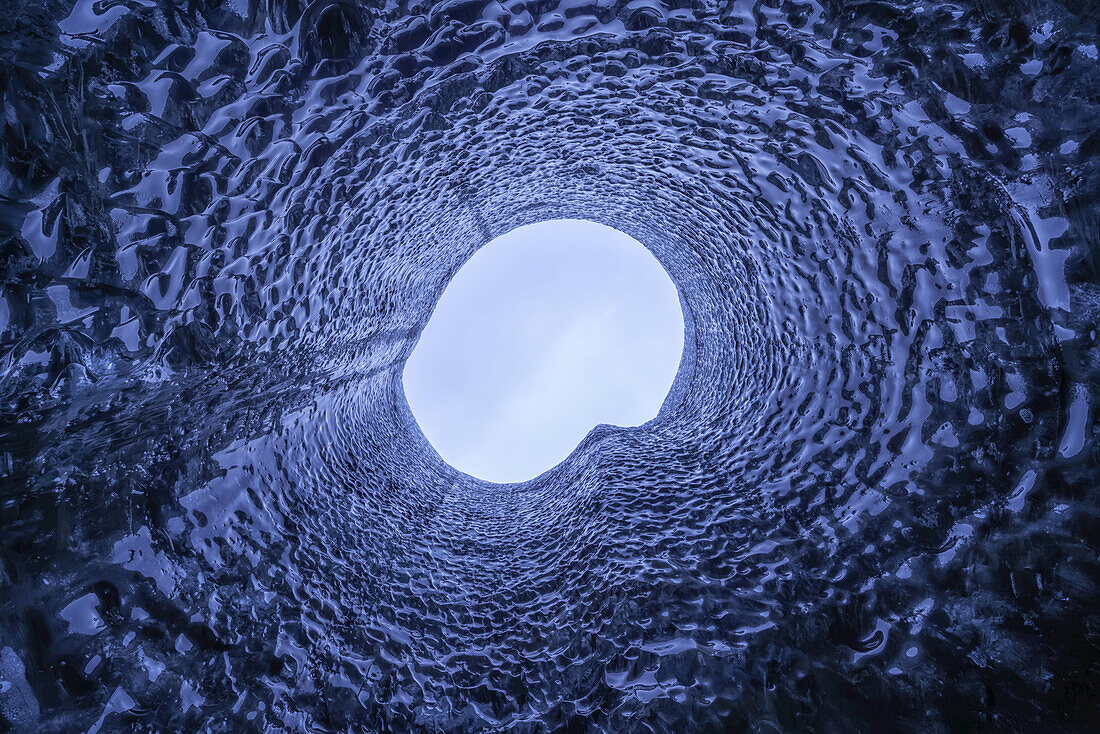 Blick nach oben durch ein Loch im Dach der Eishöhle; Island