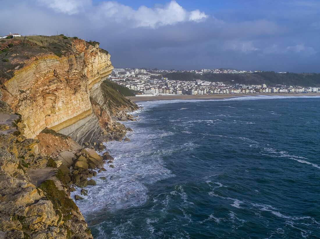 Rugged cliffs and beach along the coastline of Nazare, Portugal, the seaside resort town; Nazare, Portugal