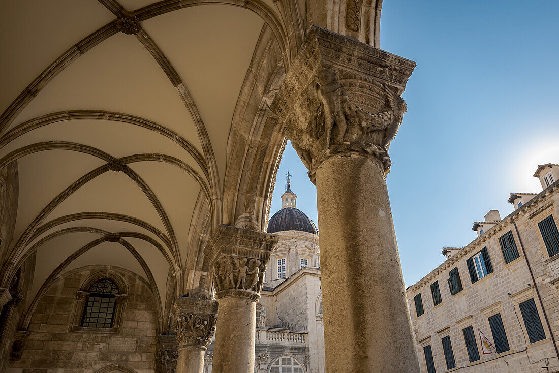 Detail der Säulen an der Fassade des Rektorenpalastes und der Kathedrale im Hintergrund; Dubrovnik, Gespanschaft Dubrovnik-Neretva, Kroatien.