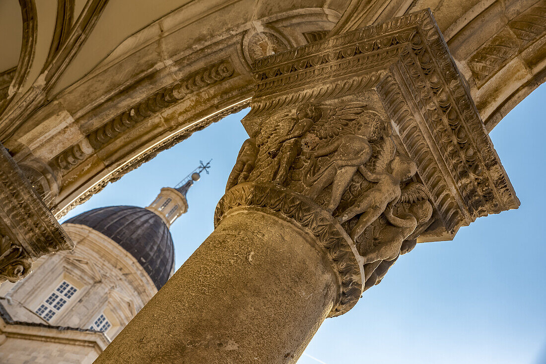 Detail der Säulen in der Fassade des Rektorenpalastes und die Kathedrale im Hintergrund; Dubrovnik, Gespanschaft Dubrovnik-Neretva, Kroatien