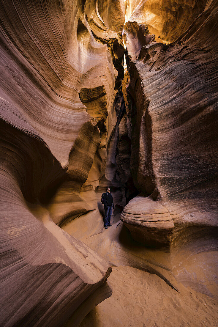 Mann stehend in einem Slot Canyon bekannt als Canyon X, in der Nähe von Page; Arizona, Vereinigte Staaten von Amerika