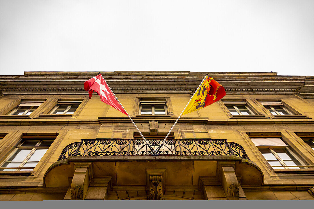 Gebäudefassade und Balkon mit Fahnen der Schweiz und Genfs; Genf, Genf, Schweiz