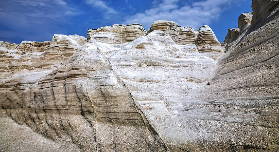 White rock formations and blue sky with cloud; Milos, Greece