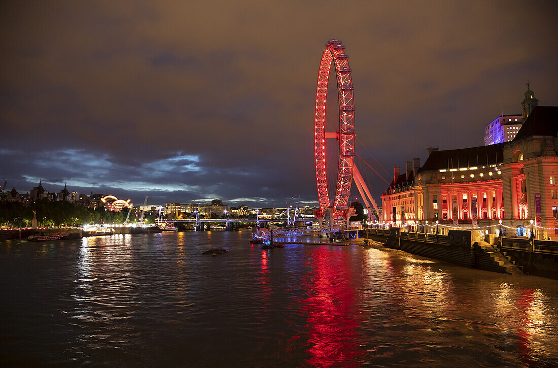 Rot beleuchtetes Riesenrad London Eye am Ufer der Themse; London, England.