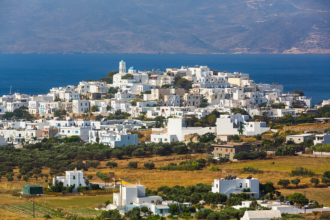 Stadt an der Küste der Insel Milos mit weißen Gebäuden und blauem Meer; Adamas, Insel Milos, Kykladen, Griechenland