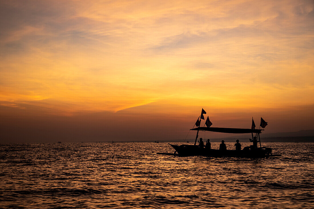 Indonesian jukung, traditional wooden outrigger canoe at sunrise; Lalang, Bali, Indonesia