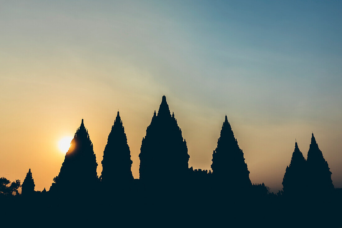 Sunset at Prambanan Temple with silhouetted peaks; Yogyakarta, Indonesia