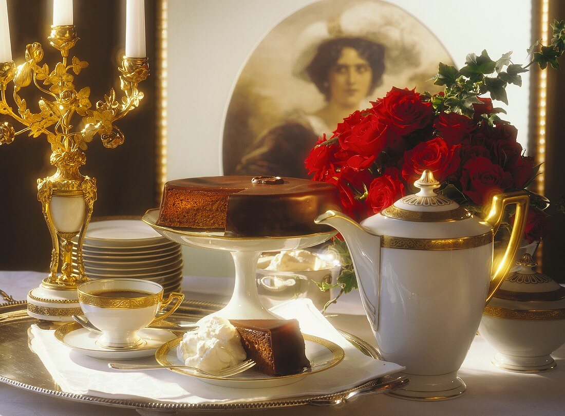 Sacher torte on festive coffee table, decor: picture, roses