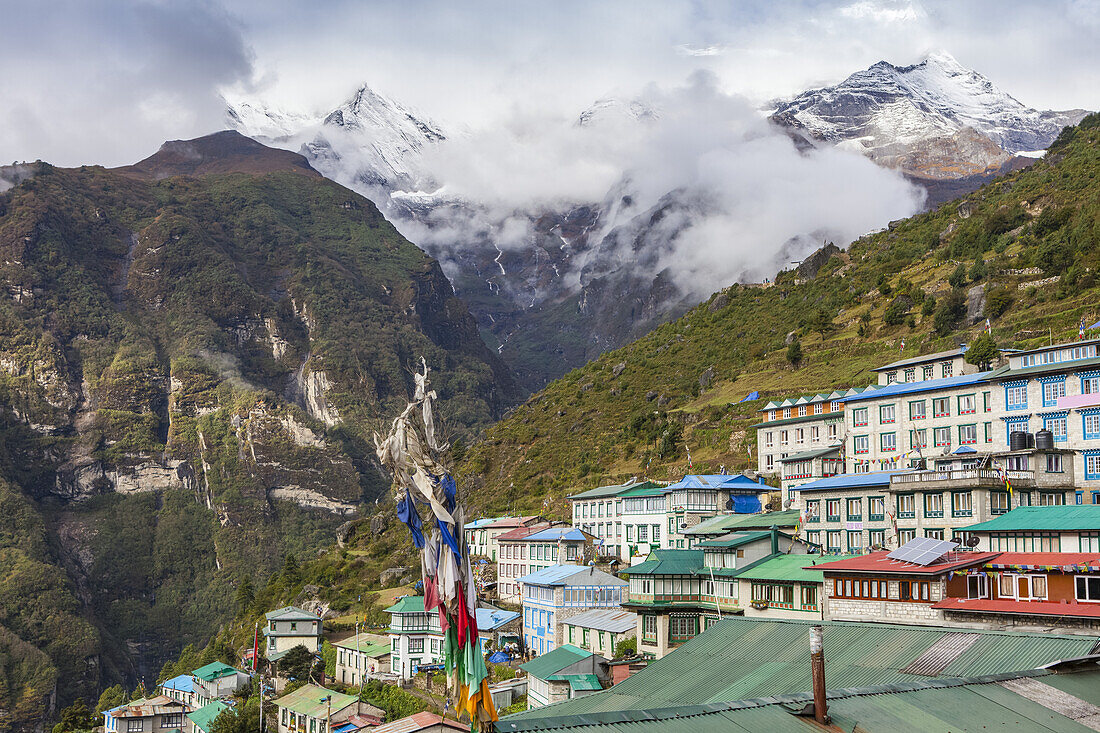 View of Namche Bazaar and the snow dusted Himalayan peaks in the distance, up valley, Sagarmatha National Park, Solokhumbu district, Nepal on an autumn day; Namche Bazaar, Solokhumbu district, Nepal