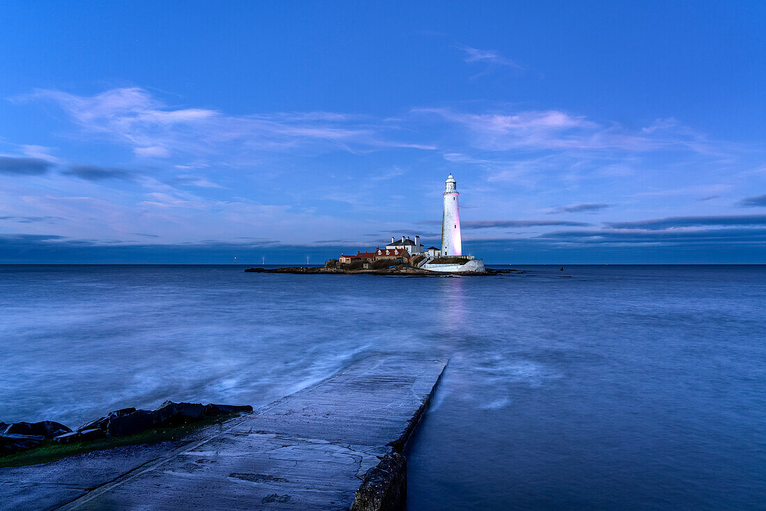 St Mary's Island Lighthouse illuminated at dusk on Whitley Bay; Tyne and Wear, Northumberland, England, United Kingdom