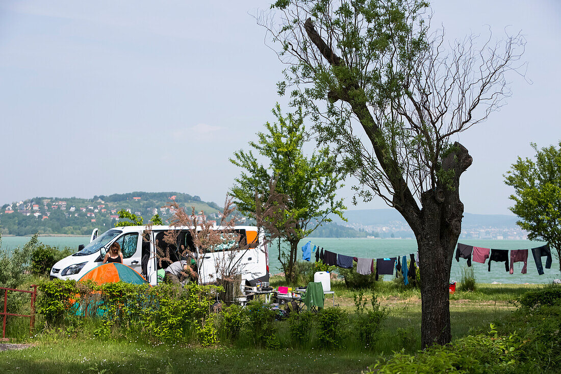 Eine Gruppe von Reisenden schlägt ihr Tageslager entlang des Plattensees auf; Zamardi, Komitat Somogy, Ungarn.