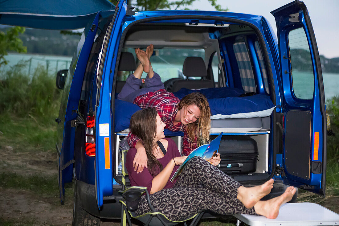 Campingplatz am Plattensee mit Reisenden, die im Wohnmobil abhängen und sich eine Zeitschrift ansehen; Zamardi, Komitat Somogy, Ungarn