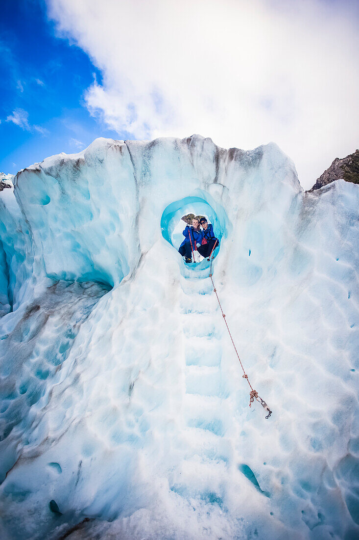 Travellers explore New Zealand's famous Franz Josef Glacier. Blue Ice, deep crevasses, caves and tunnels mark the ever changing ice; West Coast, New Zealand