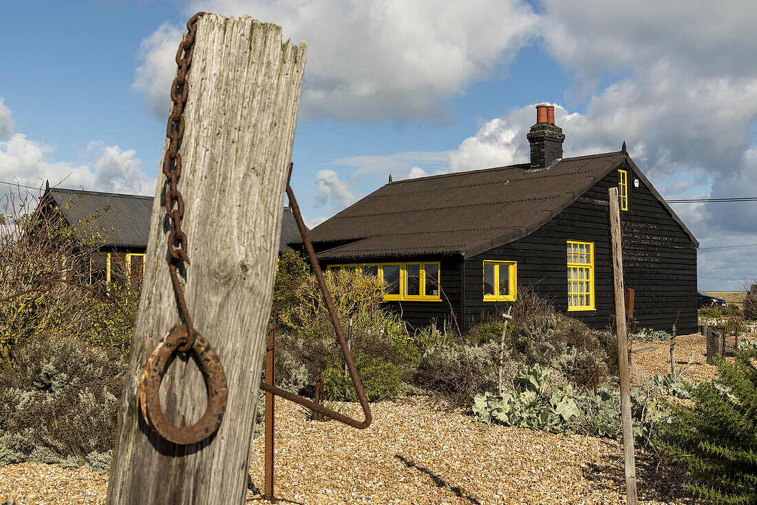 Prospect Cottage, formerly owned by the late artist and film director Derek Jarman with its seaside garden and the carved letters of the John Donne poem 'The Sun Rising' on the exterior wall of the cottage; Dungeness, Kent, England, United Kingdom