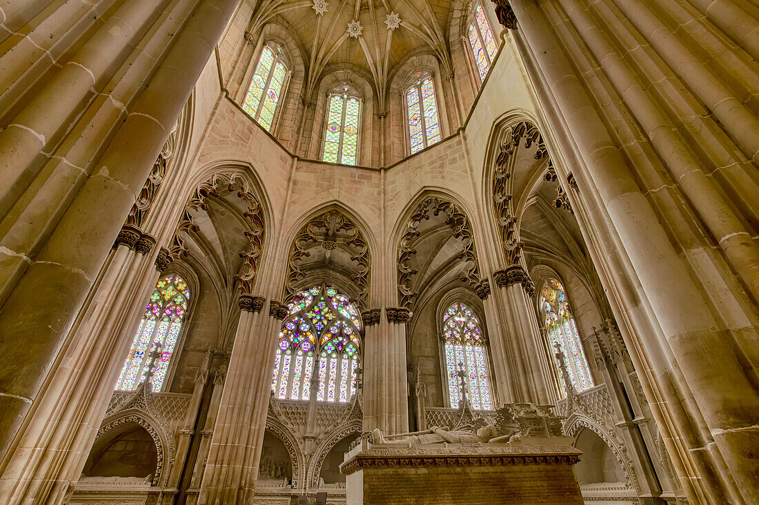 Innenansicht der Kapelle des Batalha-Klosters mit dem gemeinsamen Grabmal von Joao I. von Portugal und seiner Königin Philippa von Lancaster, umgeben vom kunstvollen Mauerwerk des Mittelschiffs mit seinen komplizierten Glasfenstern; Batalha, Bezirk Leiria, Centro-Region, Portugal.