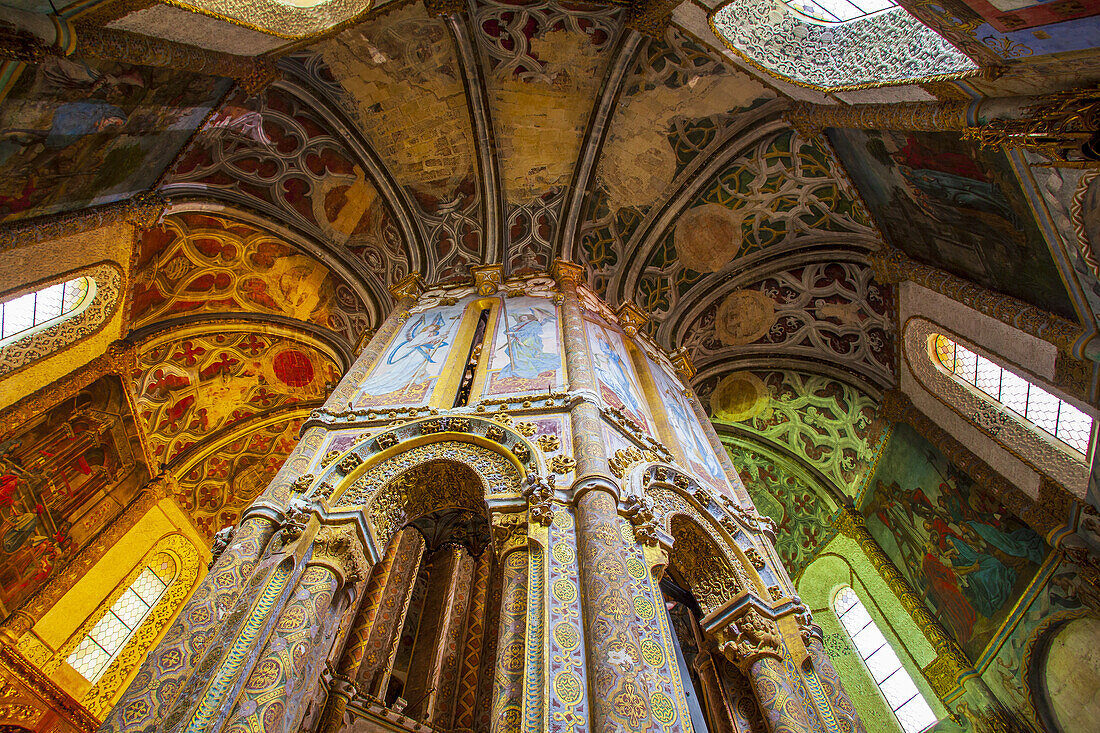 Looking up at the ceiling and Gothic arched columns of the round church covered in paintings and colorful Manueline stonework inside the Convent of Christ, founded in the 12th Century by the Knights Templars; Tomar, Santaren District, Ribatejo Province, Centro Region, Portugal