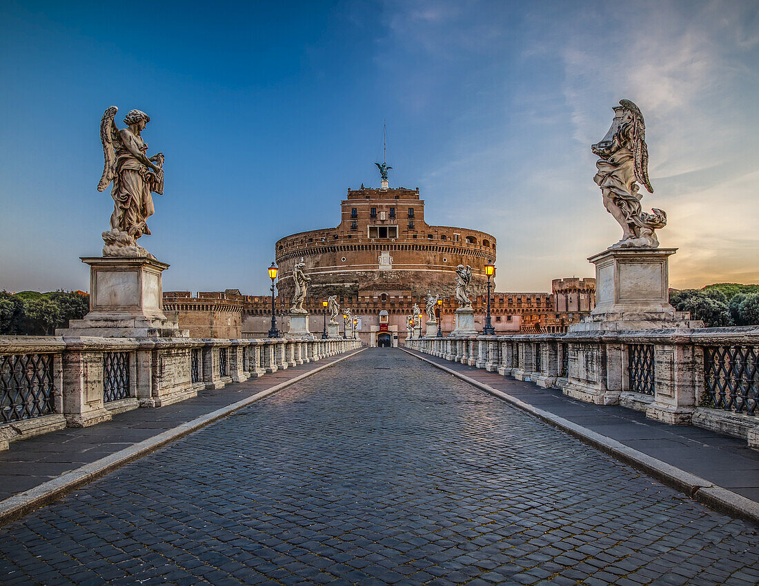 Ponte Sant'Angelo spanning the Tiber River and lined with statues of angels leading to the Castel Sant'Angelo (Mausoleum of Hadrian) at dusk; Rome, Lazio, Italy