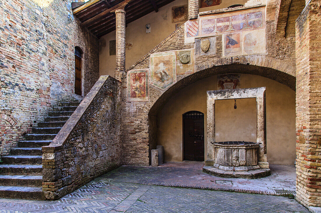Mittelalterlicher Wasserbrunnen im Hof des Palazzo del Popolo; San Gimignano, Provinz Siena, Toskana, Italien.