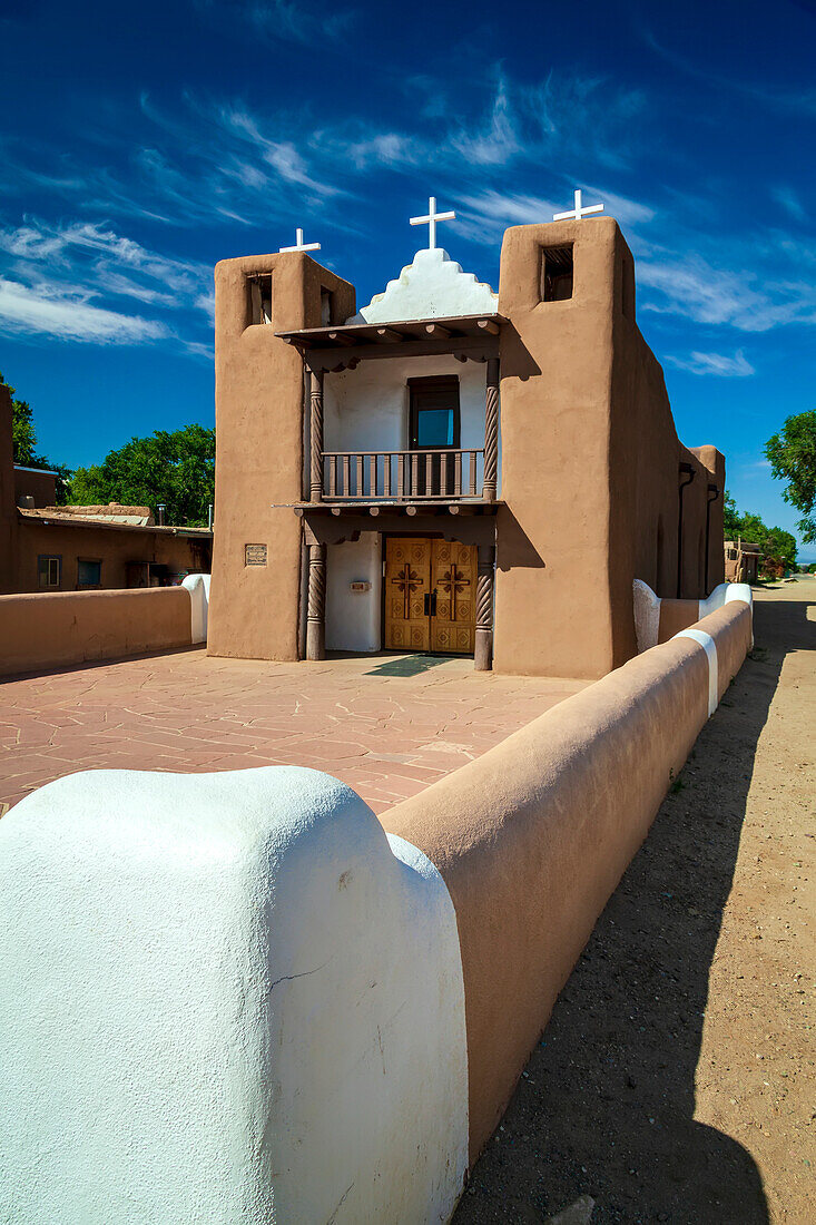 Die Lehmfassade der Kirche St. Geronimo in der alten indigenen Gemeinde Taos Pueblo, die Mitte des 19. Jahrhunderts anstelle des im Mexikanisch-Amerikanischen Krieg zerstörten Originals wiederaufgebaut wurde; Taos, New Mexico, Vereinigte Staaten von Amerika.