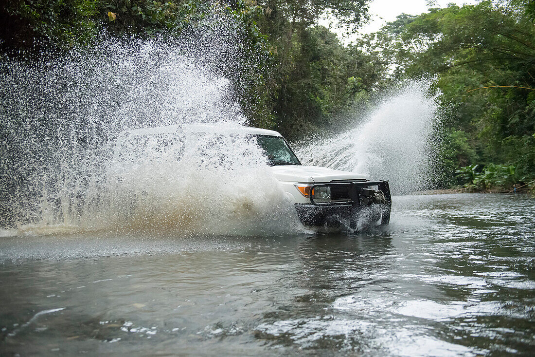 Ein Safarifahrzeug plätschert durch eine Flussdurchquerung im costaricanischen Regenwald auf der Osa-Halbinsel; Puntarenas, Costa Rica.