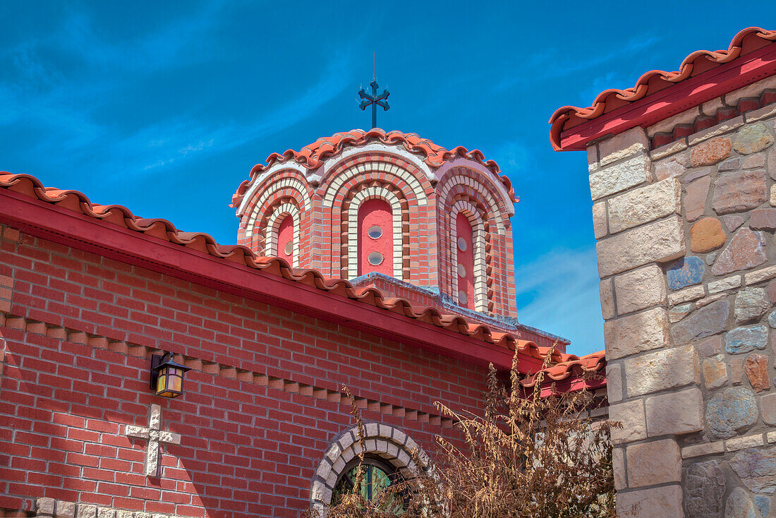 Nahaufnahme der verzierten Kuppel und des Ziegeldachs mit Ziegel- und Steinfassade der Kapelle des Heiligen Nikolaus im griechisch-orthodoxen St. Antonius-Kloster; Florence, Arizona, Vereinigte Staaten von Amerika.