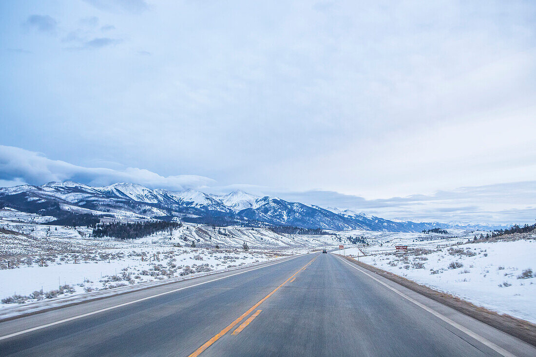 Eine Fahrt auf einem verschneiten, leeren Highway durch den Süden Colorados an einem bewölkten Tag; Colorado, Vereinigte Staaten von Amerika