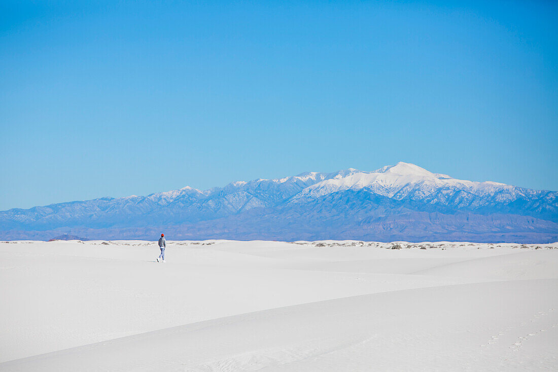 Tourist erkundet den schönen, weißen Sand der Dünenfelder im White Sands National Park; White Sands National Park, New Mexico, Vereinigte Staaten von Amerika.