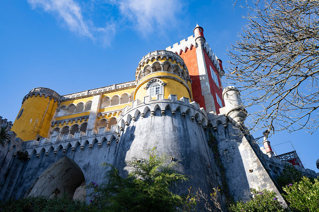 Das auf einem Hügel gelegene Schloss Palacio Da Pena mit seinen bunten Türmen und der Steinmauer in den Sintra-Bergen; Sintra, Bezirk Lissabon, Portugal.