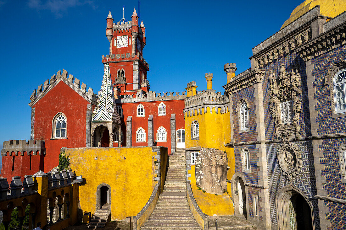 Das auf einem Hügel gelegene Schloss Palacio Da Pena mit seinen farbenfrohen Türmen und Steintreppen in den Sintra-Bergen; Sintra, Bezirk Lissabon, Portugal