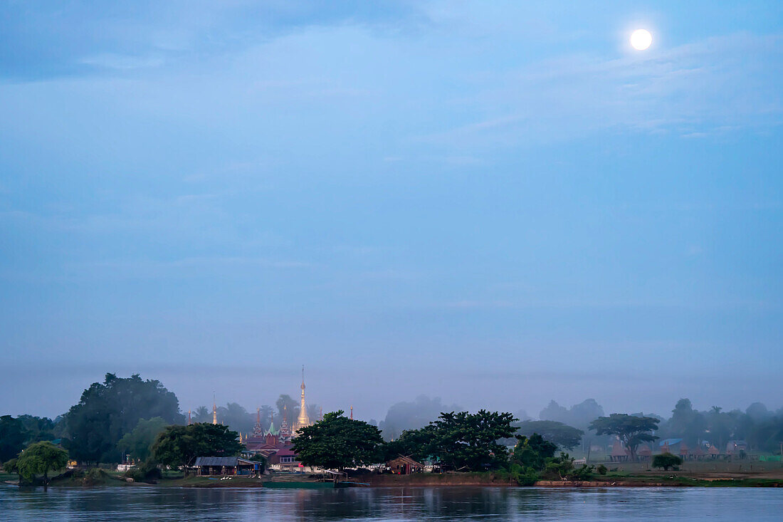 Der Vollmond geht über einer Dorfstupa am dschungelbedeckten Ufer des Ayeyarwady (Irrawaddy) Flusses auf; ländlicher Dschungel, Kachin, Myanmar (Burma)