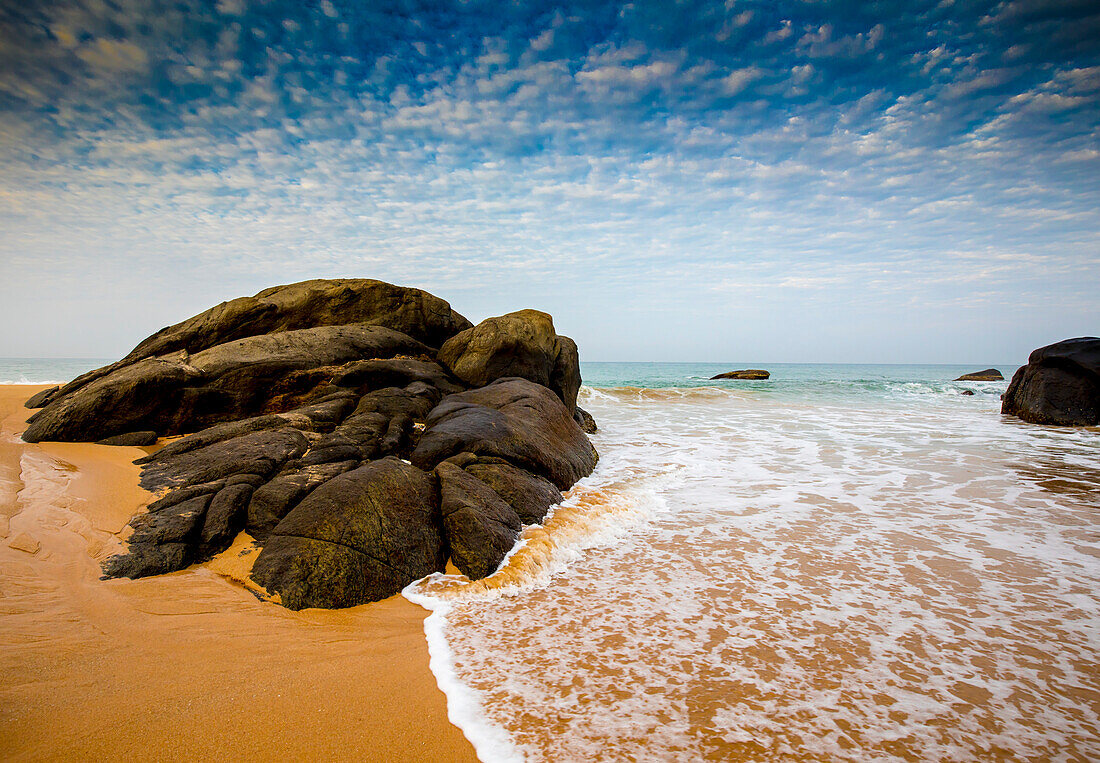 Boulders and sea surf at Kumu Beach on the Indian Ocean coast near Balapitiya; Balapitiya, Galle District, Sri Lanka